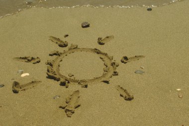 Kıbrıs'ta yaz güneşli plajda birkaç çakıl ve küçük bir dalga ile ıslak kum çizim Güneş şekli 