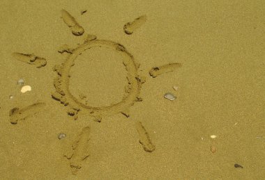 Kıbrıs'ta yaz güneşli plajda birkaç çakıl ile ıslak sarı kum üzerinde çizim Güneş şekli 