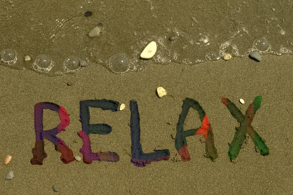 Bright Multi Colored Word Relax Wet Yellow Sand Few Pebbles — Stock Photo, Image