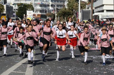 Limasol, Kıbrıs, 10 Mart 2019: Yıllık Limasol Karnaval Festivali'nin Büyük Geçit Töreni sırasında Başpiskopos Makarios Iii Bulvarı boyunca koşan neşeli erkek ve kız grubu