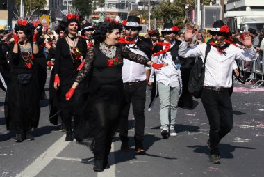 Limasol, Kıbrıs, 10 Mart 2019: Yıllık Limasol Karnaval Festivali'nin Büyük Karnaval Geçit Töreni'ne boyalı yüzlerle siyah ve kırmızı kostümlü neşeli erkek ve kadınlar