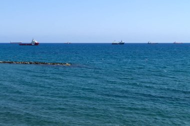 Güneşli bir günde ufukta birkaç gemi ile parlak mavi denizpanoramik görünümü 