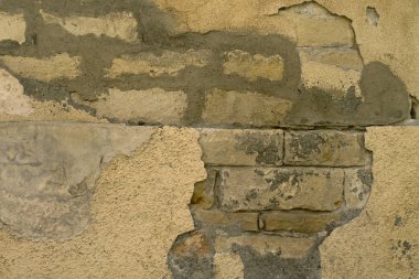 Yıpranmış soyulmuş bej boya ile eski bir tuğla duvarın bir parçası