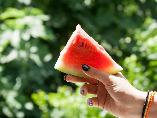 Watermeloen Plak Hand Wazig Groene Achtergrond Zonlicht — Stockfoto