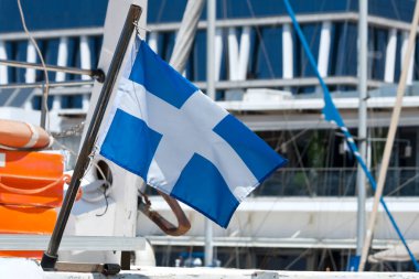 Yunanistan 'ın ulusal bayrağı deniz limanına demir atmış teknede dalgalanıyor