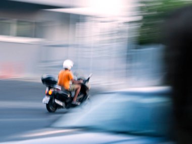 Motosikletli tanınmayan çocuk hızlı hareket ediyor, bulanık hareket ediyor.