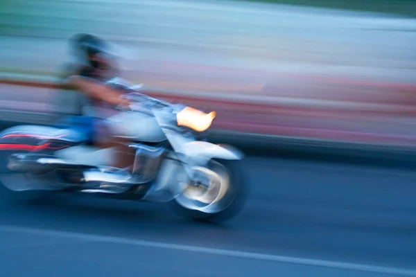 Motorcycle moving fast on night road, blurred motion