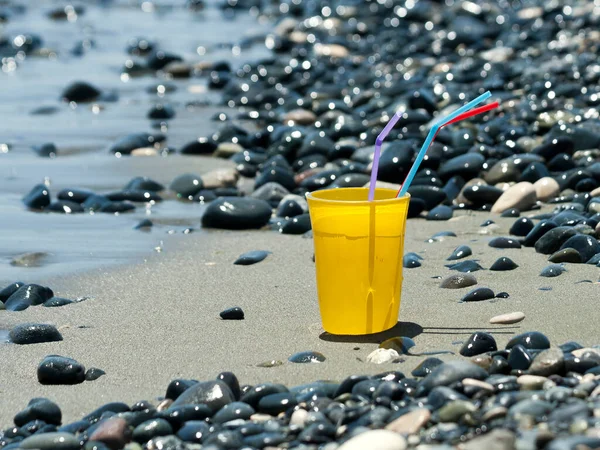 Geel Drinkglas Met Kleurrijke Rietjes Het Strand Tussen Glinsterende Stenen — Stockfoto