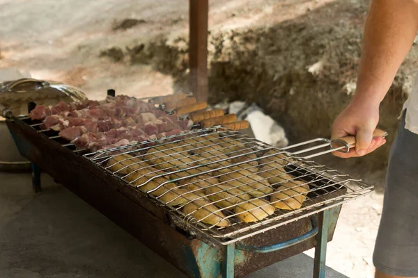바베큐 인들은 피크닉 장에서 스커어 인들과 요리하는 사람들의 손으로 그릴을 — 스톡 사진