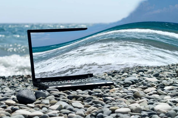 Laptop Ležící Pláži Mezi Šedými Kameny Vlnité Moře — Stock fotografie