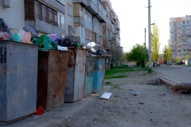 Çok katlı bir binanın önündeki çöp tenekelerini doldurdum.