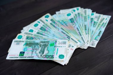 Ahşap bir arka planda bir yığın Rus parası.