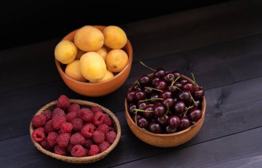 Vişne, kayısı, ahududu ahşap arka planda.