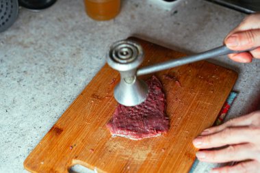 Tahtada özel bir çekiçle et dövüyorsun.