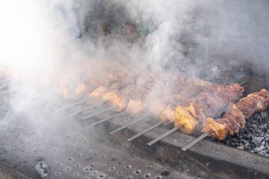 Dumandaki et kömürde kızarıyor.