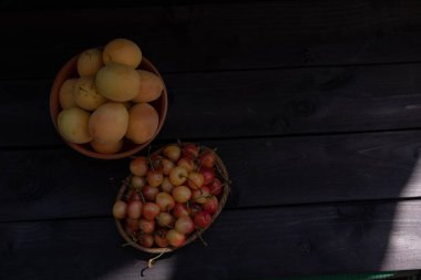 Ahşap bir arka planda vişne ve kayısı.
