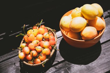 Ahşap bir arka planda vişne ve kayısı.