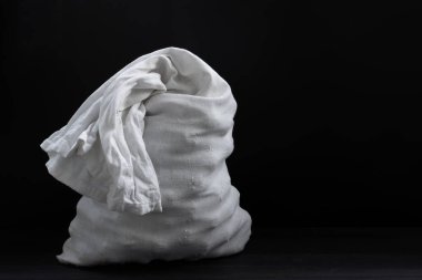 Tahta arka planda beyaz bir çanta.