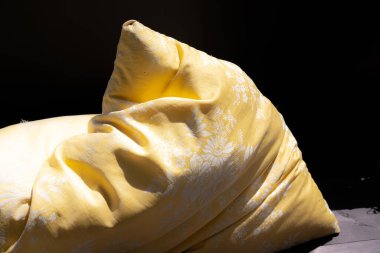 Yastık ahşap bir arka planda yatıyor.