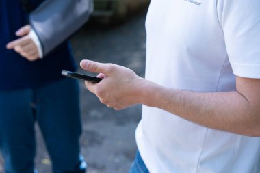 Elinde cep telefonu tutan bir adam.