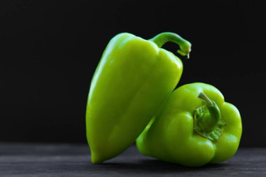 Yeşil, siyah arka planda dolmalık biber.
