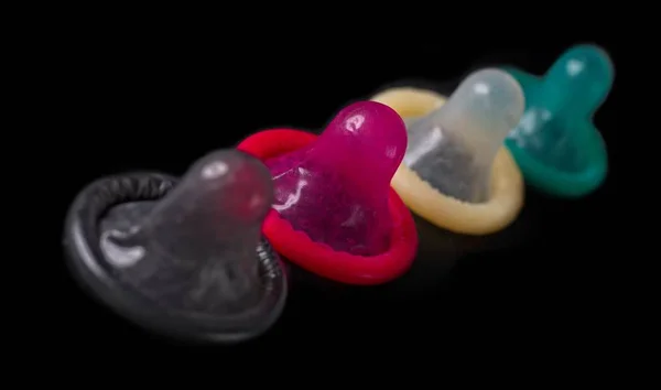 Разноцветные Презервативы Ряд Изолированы Черном — стоковое фото
