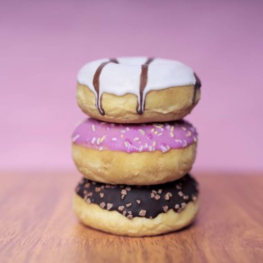 Pembe bir arka plan üzerinde tatlı sırlı çörek yığını.