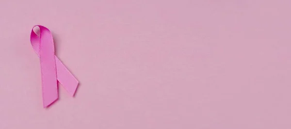 粉色丝带的乳腺癌意识标志粉红色背景 带有复制空间的全景图像 — 图库照片