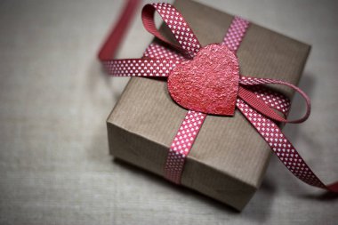 Hediye kutusu kırmızı kurdele ve kalpleri ile. Sevgililer günü tebrik kartı ile metin için yer.