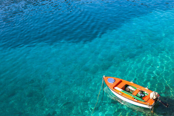 Лодка на кристально чистой воде. Фотография сделана на Ионическом острове Кефалония в Греции
