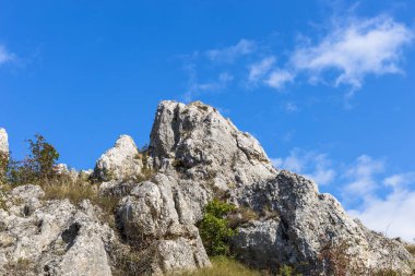 Üst mavi bir gökyüzü bulutlu ve kayalık tepe