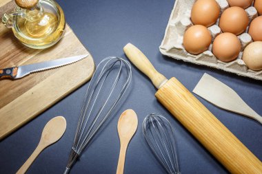 Mutfak eşyaları, yağ ve yumurta koyu arka plan üzerinde. Fırın kavramı, yüksek açıdan görünümü.