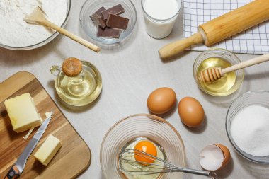 Kek pişirme için malzemeler. Yumurta, un, tereyağı, yağ, süt, bal, şeker ve çikolata açık renkli. Fırın kavramı, yüksek açıdan görünümü.