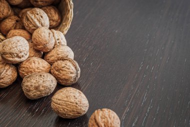 Koyu ahşap bir masa üzerinde sepet içinde ceviz