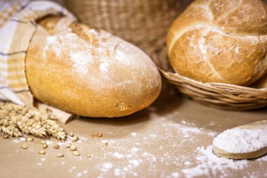 Fırından yeni çıkmış ekmek, buğday ve un rustik bir arka plan üzerinde