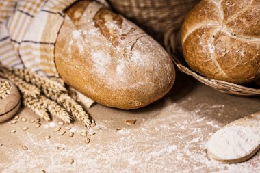 Fırından yeni çıkmış ekmek, buğday ve un rustik bir arka plan üzerinde