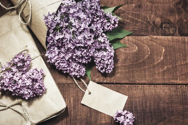 Ahşap bir masada leylak hediye ve buket