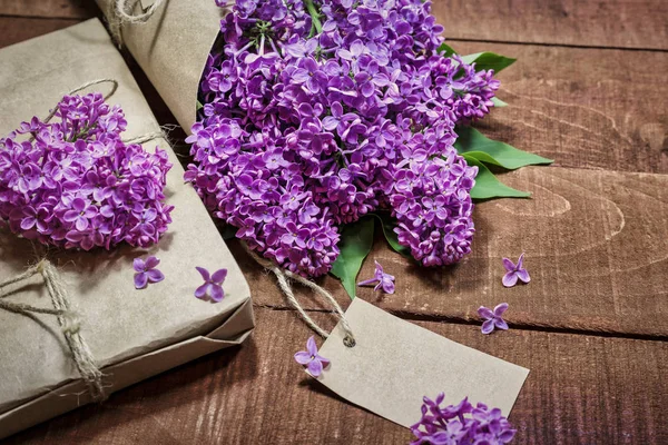 Ahşap bir masada leylak hediye ve buket