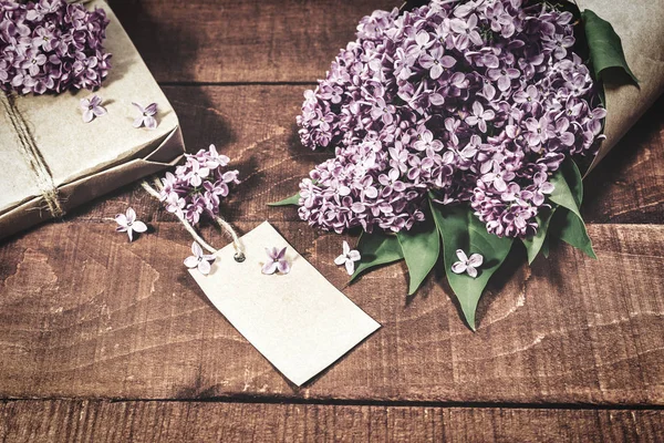Ahşap bir masada leylak hediye ve buket