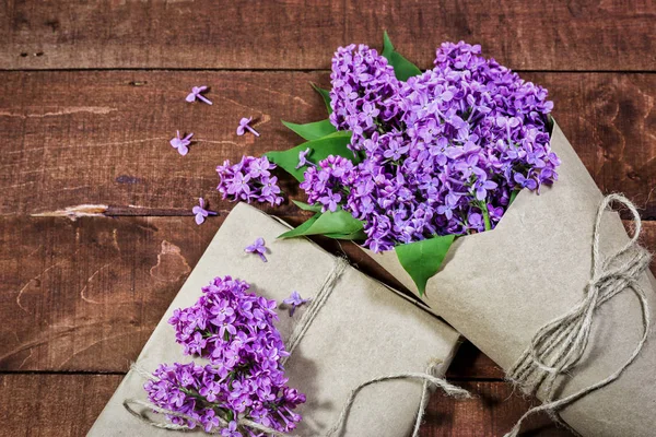 Ahşap bir masada leylak hediye ve buket