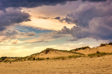 Sahilde fırtınalı bulutlu gökyüzünde Güneş ışığı