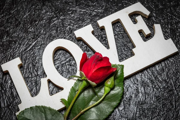 Siyah arka planda kırmızı gül ile Kelime aşk