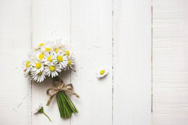 Kırsal ahşap zemin üzerinde beyaz papatya çiçekleri, fotokopi alanı ile üst manzara.
