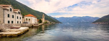 Karadağ, Kotor Körfezi (Adriyatik Denizi), Stoliv köyü, gri dağlara karşı taş evleri olan Picturesque Akdeniz köyü. Seyahat kavramı, arkaplan.