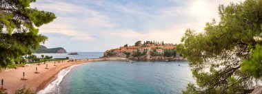 Eski tarihi kentin ve Karadağ 'ın (Adriyatik Denizi) küçük Sveti Stefan adasındaki tatil köyünün güzel panoramik fotoğrafı. Seyahat kavramı, arkaplan.