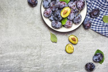 Yapraklı bir tabakta bir sürü taze erik, yazı için yeri olan üst manzara. Sağlıklı meyve.