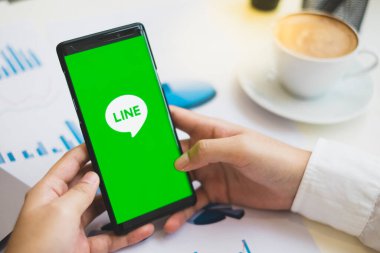 RAYYONG, THAILAND - 20 Ekim 2018: Samsung Galaxy Note 9 açık hat uygulama logosunu tutan elleri kapatın. LINE uygulaması Japonlar tarafından ücretsiz mesaj gönderen ve ücretsiz arama yapan popüler bir iletişim uygulamasıdır.