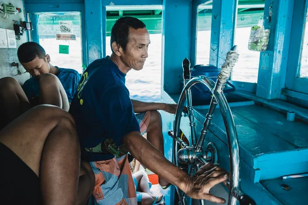 Rayong, Tayland, 23 Şubat 2020: Gemi turistleri SAMED Adası 'na taşırken kıdemli denizci dümeni kullanıyor. Deniz, seyahat ve ulaşım kavramı.