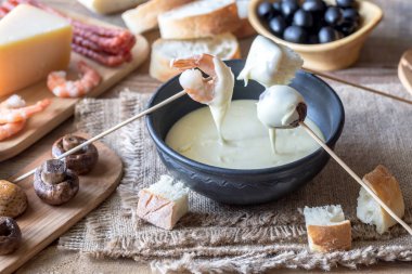 Bowl of fondue with appetizers clipart