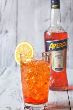 Sumy, Ukrayna - 29 Ağustos 2018: Cam, Aperol Spritz kokteyl Aperol şişe beyaz ahşap zemin üzerinde. Aperol ünlü İtalyan Aperatif olduğunu.